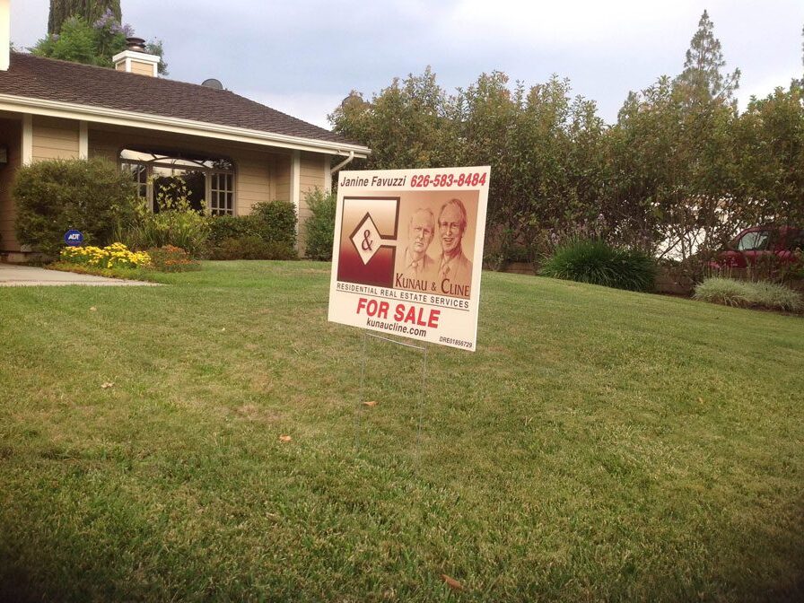 Kunau and Cline for sale sign in the front yard of a house.