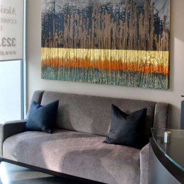 Gray couch with picture hanging on wall above it.