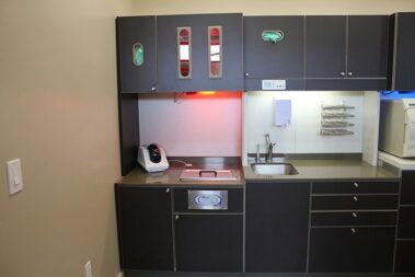 Dental room with sink and cabinets.