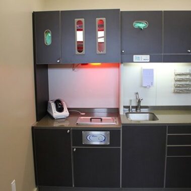 Dental room with sink and cabinets.