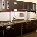 Wide dental room with sink and equipment.
