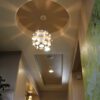 Small chandelier hanging from a ceiling in a dentist office.