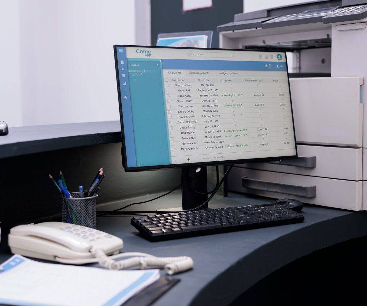 Desk with computer, phone, and copier.
