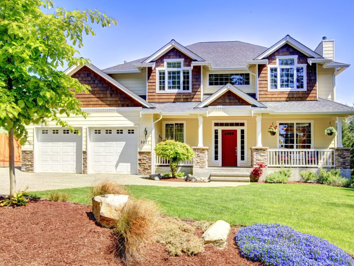 Beautiful yellow house on a small grassy hill.
