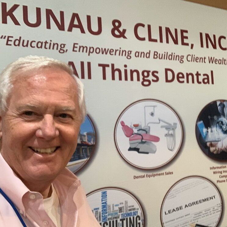 Cliff Houser posing in front a poster that says "All Things Dental".