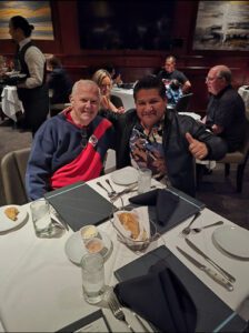 Dentist Enmer Tadeo sitting with Cliff House at a table.